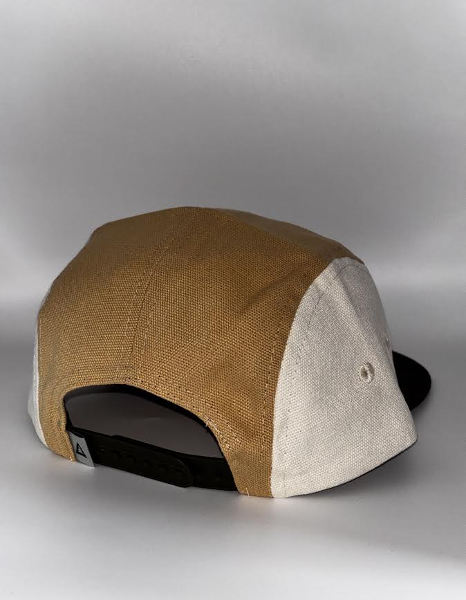 back of Leave No Trace hat — golden/cream panels, plastic snap closure): "Back view of Landmark Project Leave No Trace Camp Hat in golden tan and cream colorblock organic cotton with black snap closure and Landmark Project label"
