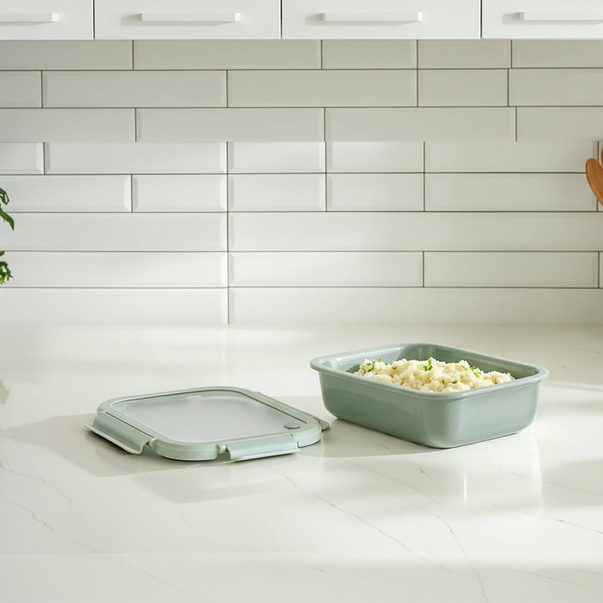 One green rectangular container with lid on a kitchen counter.