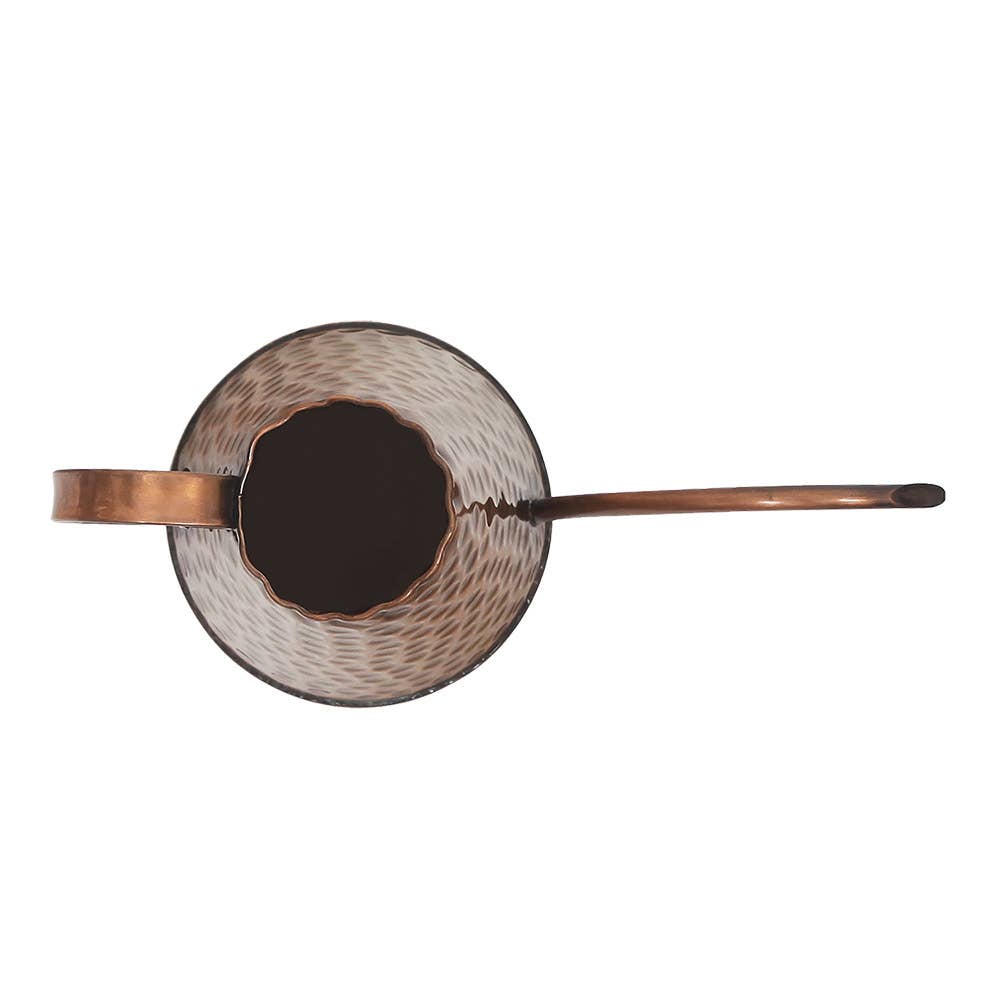 Overhead view of hammered copper watering can showing the scalloped opening and long spout extending from the round body