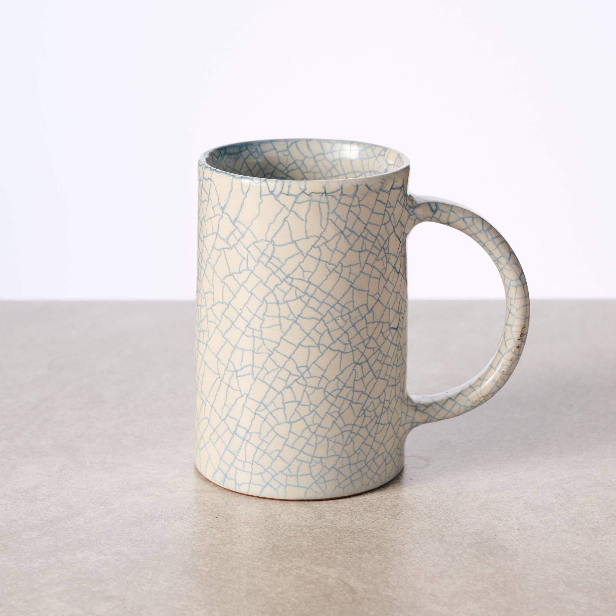 "Tall handcrafted ceramic mug with blue crackle glaze, made in Nepal by Ten Thousand Villages artisans
