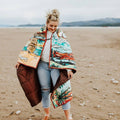 Woman standing on a beach wearing a colorful quilted jacket