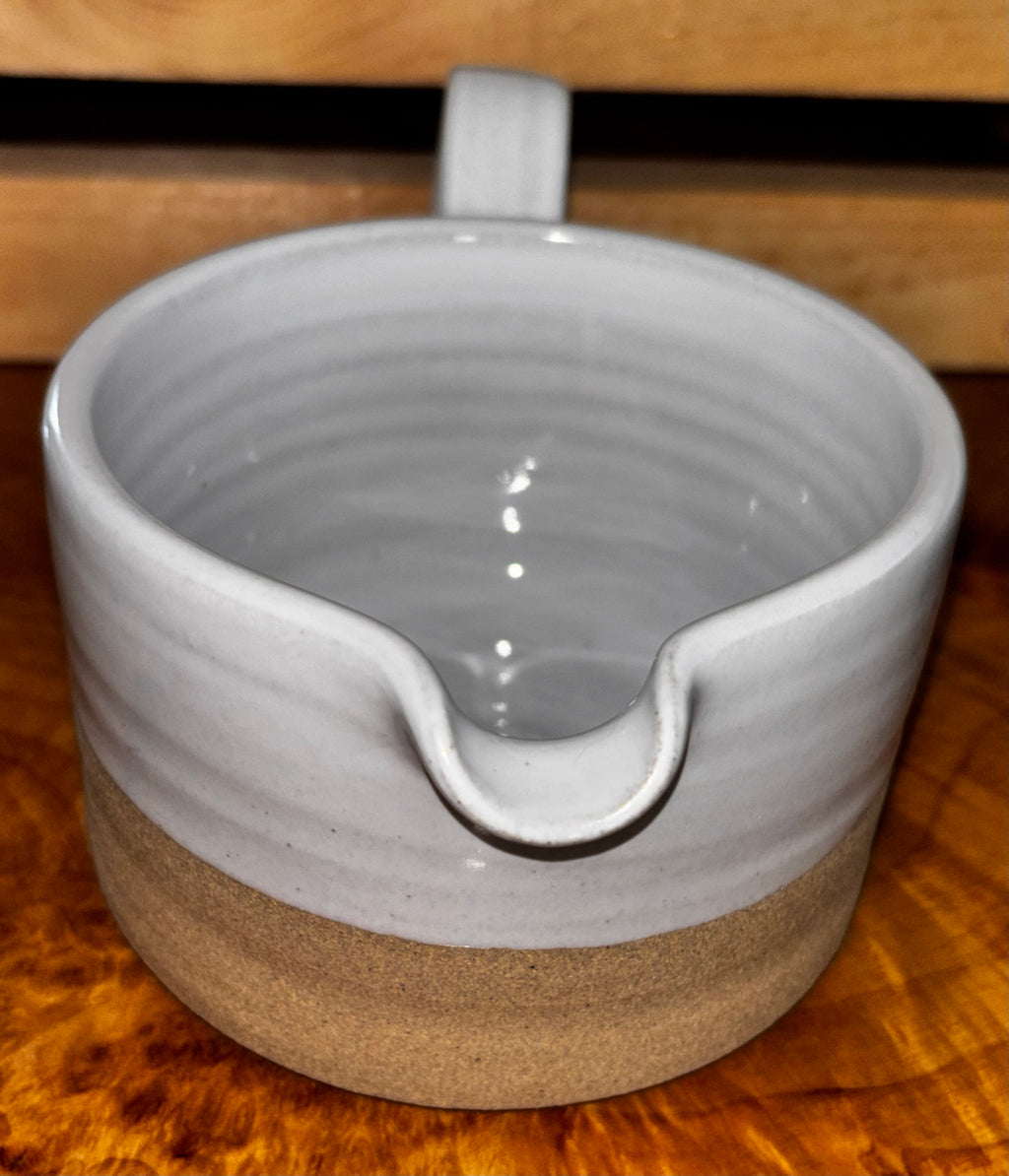 Top-down interior view on live edge wood → "Overhead view of Farmhouse Pottery Silo stoneware gravy boat showing the smooth white glazed interior with hand-thrown spiral, displayed on a live edge wood surface"