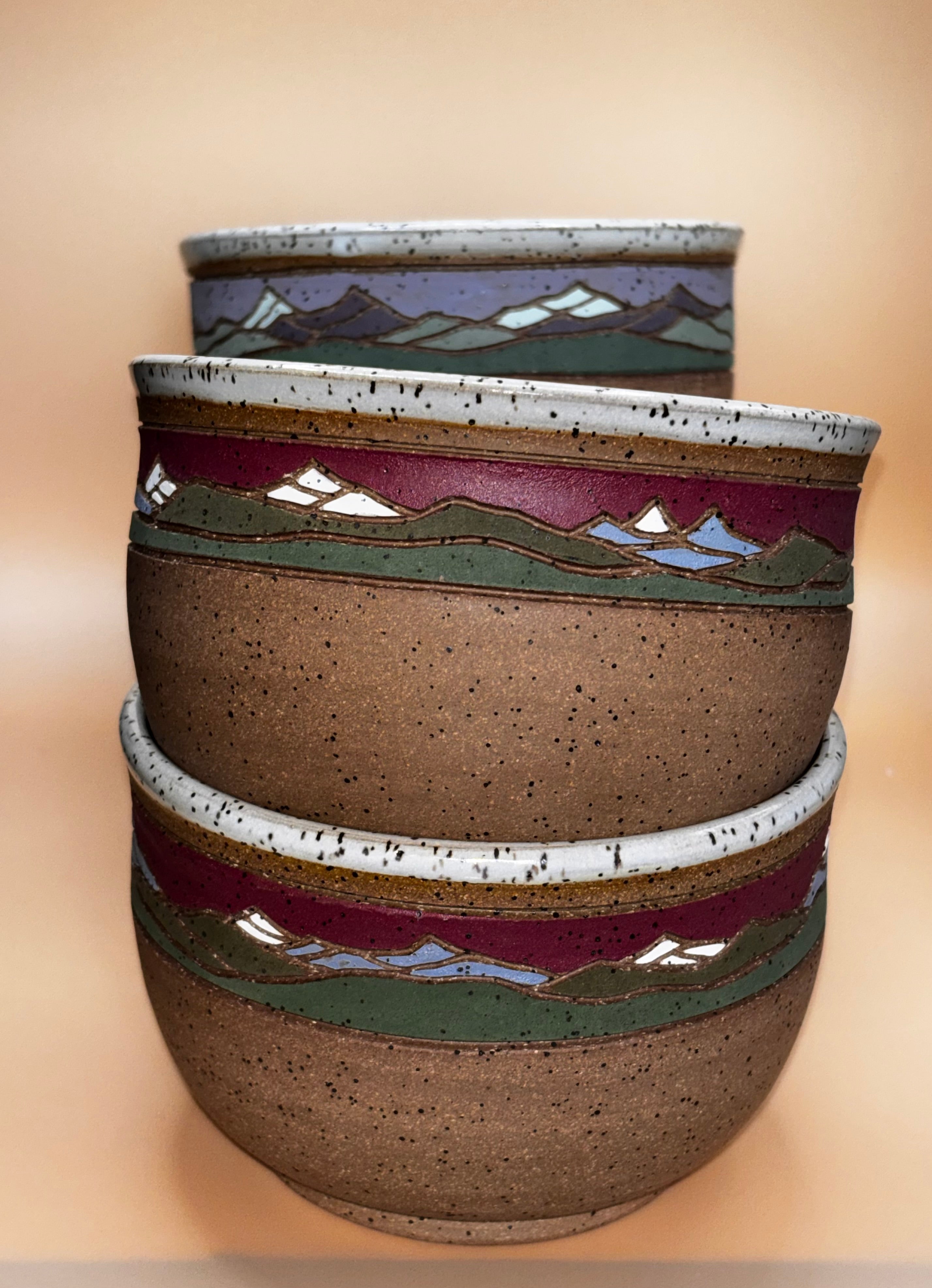 Crimson Ridge set stacked (exterior, side view):

"Set of 2 handmade speckled stoneware bowls with deep crimson and sage green mountain landscape band, stacked exterior view — Forest Jeannie Pottery"