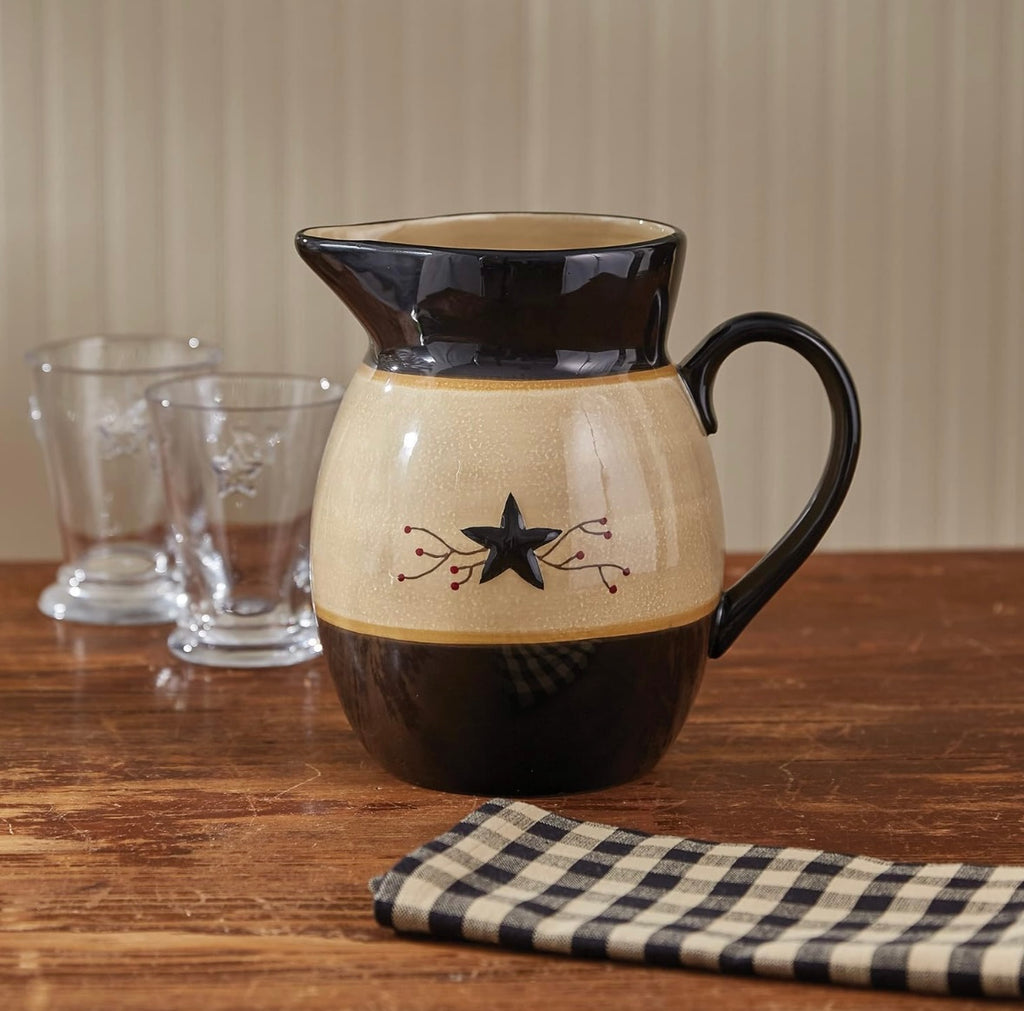 Park Designs Star Vine dolomite pitcher styled on a farmhouse wood table with gingham napkin and glass tumblers"