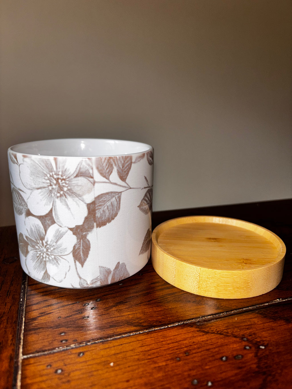 White ceramic floral planter with grey botanical floral print shown with bamboo tray removed beside it