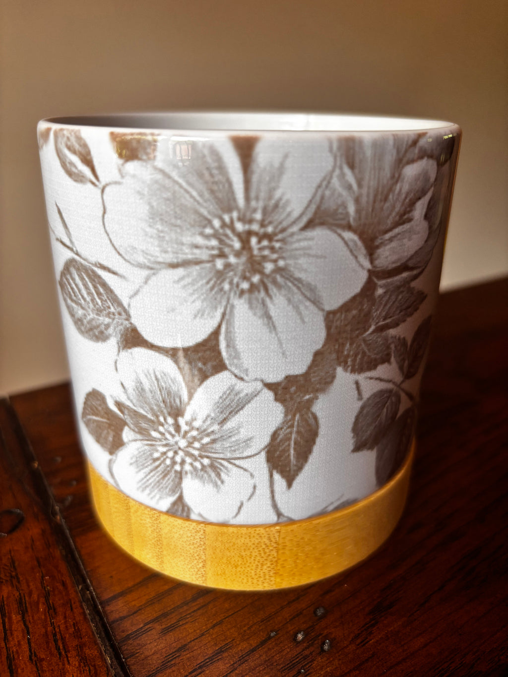White ceramic floral planter with grey botanical floral print and natural bamboo tray base, close-up view