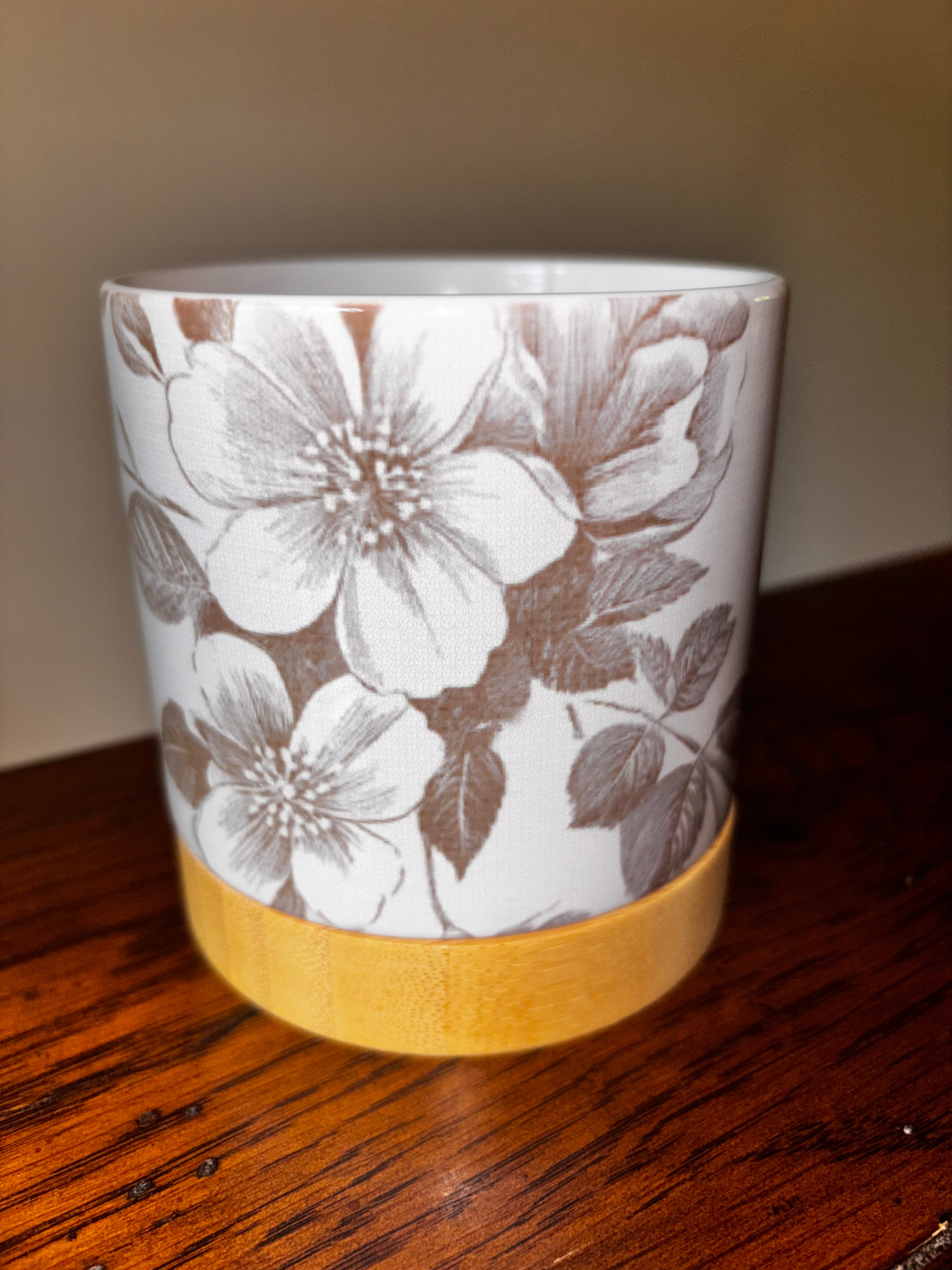 White ceramic floral planter with grey botanical floral print and natural bamboo tray base, angled view
