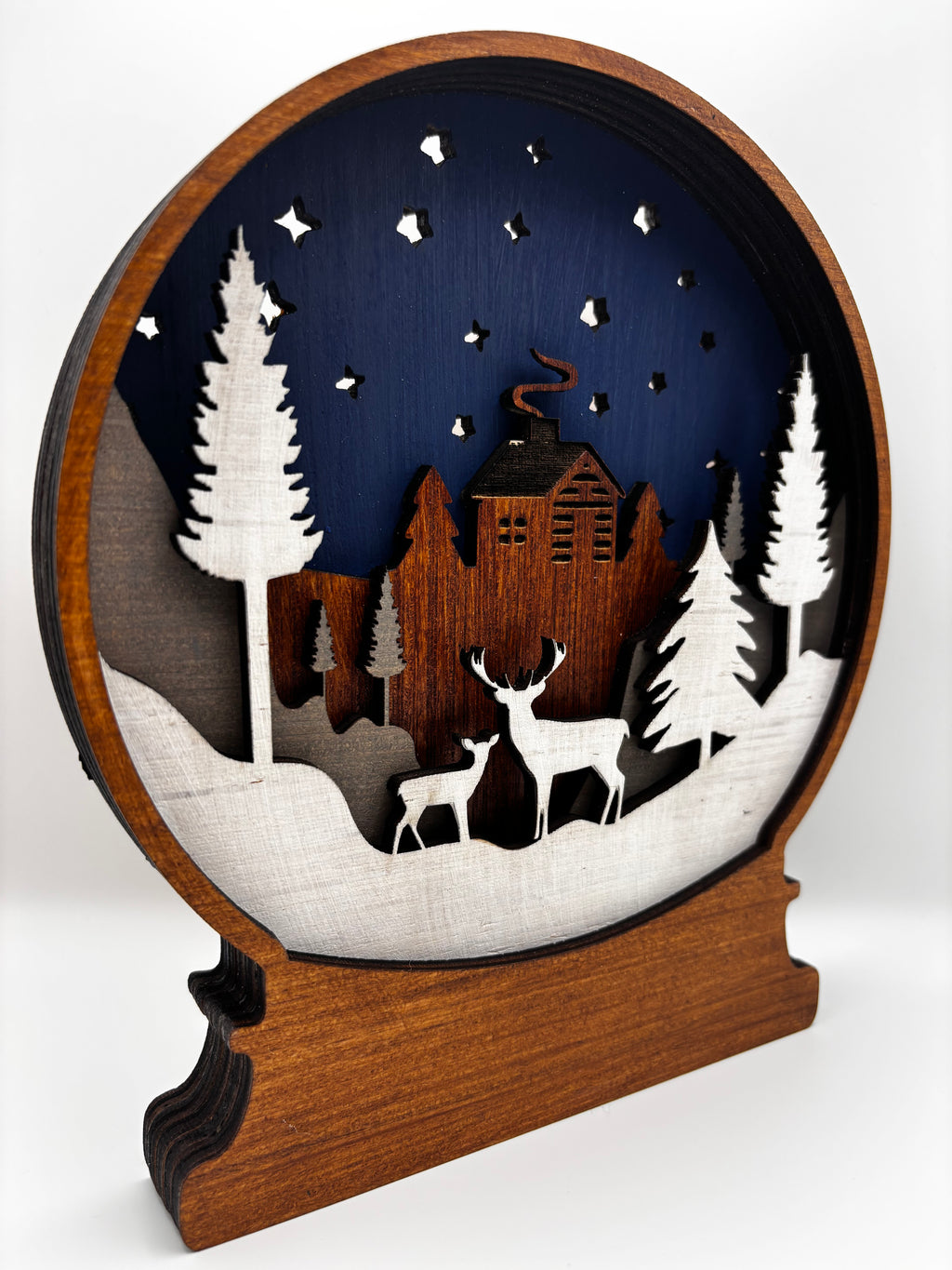 Opposite angled view of Winter Deer snow globe showing its wooden base and layered woodland scene.