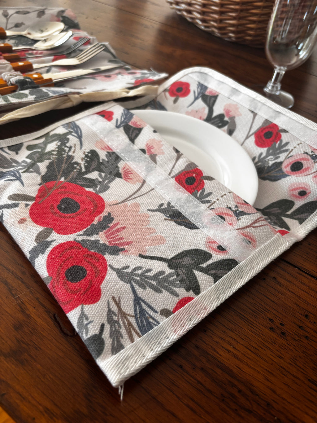 Close-up of a white plate tucked into the matching floral storage sleeve with a hook-and-loop closure