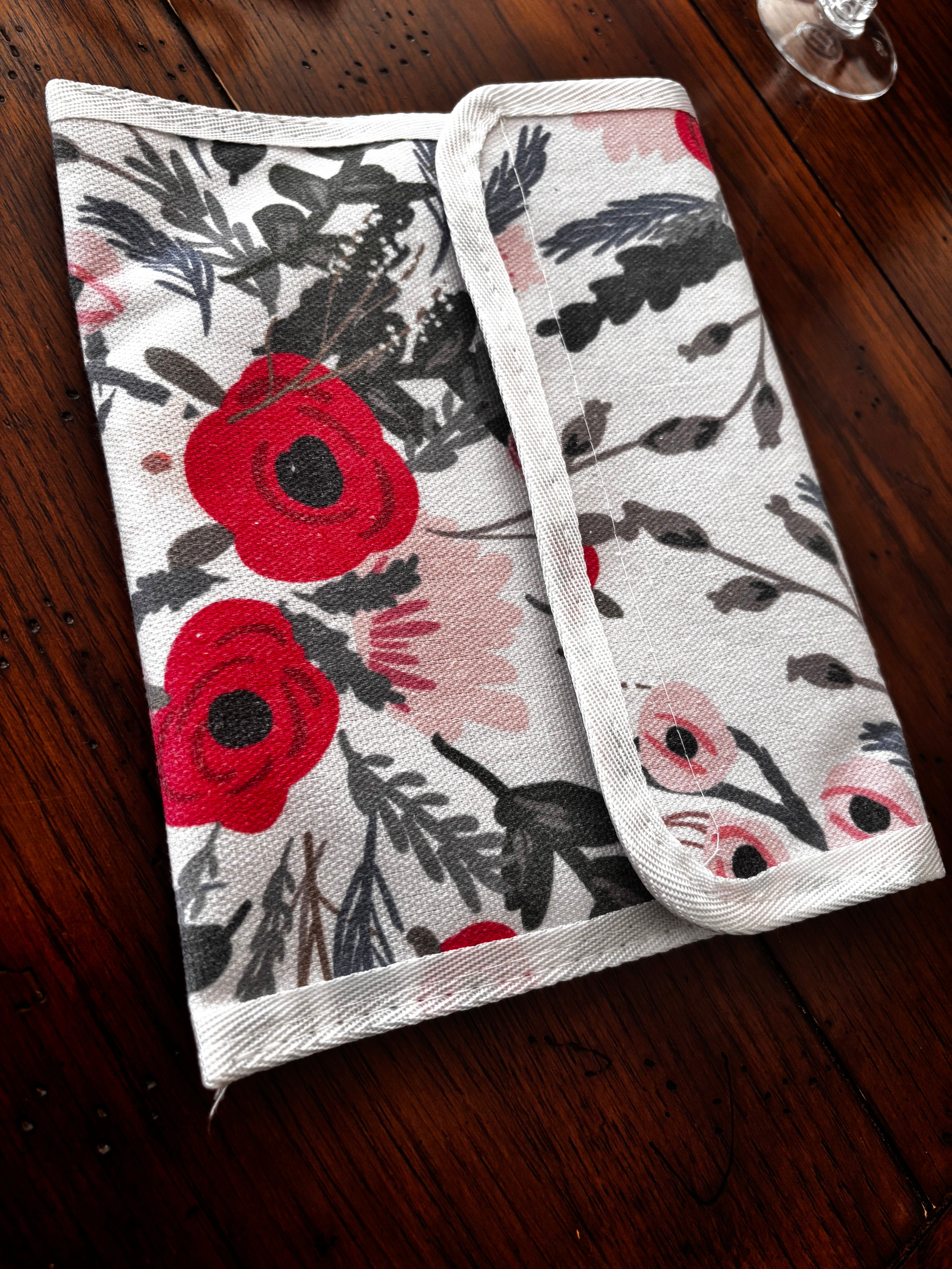 Floral plate-storage sleeve folded closed on a wooden table.