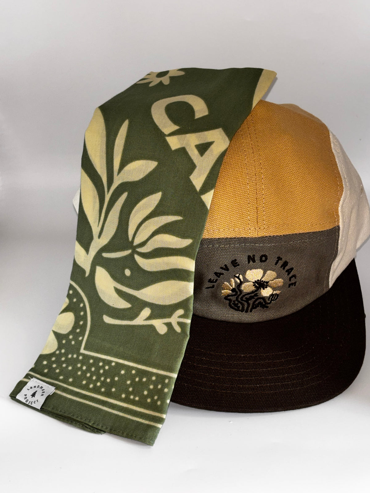 Leave No Trace hat styled with Appalachian Animals Bandana in olive green): "Landmark Project Leave No Trace Camp Hat styled with Woodsy Owl Bandana in olive green with cream botanical and owl print, Landmark Project label visible"