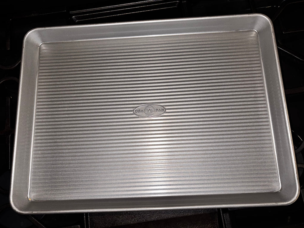 USA Pan half sheet pan showing its rectangular corrugated base, rounded corners and raised rim.