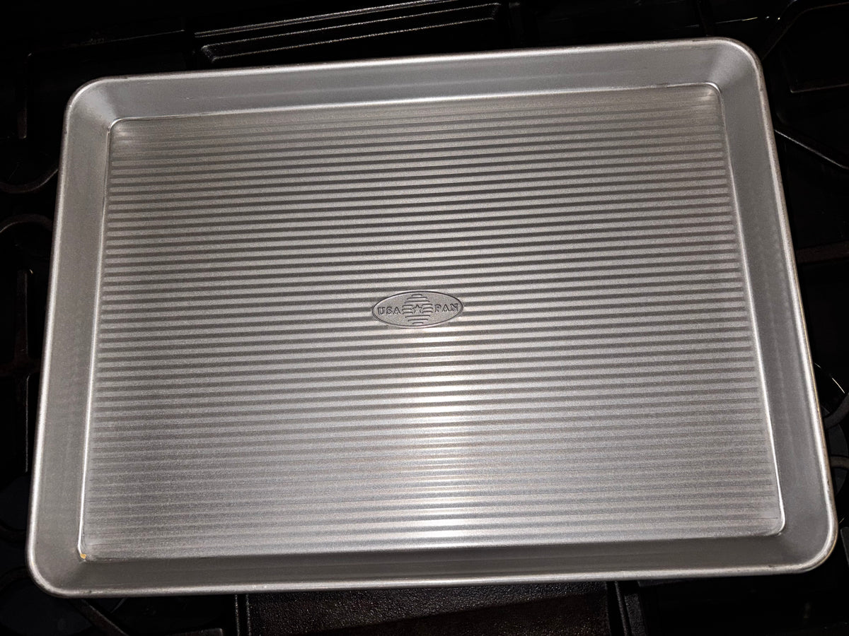 USA Pan half sheet pan showing its rectangular corrugated base, rounded corners and raised rim.