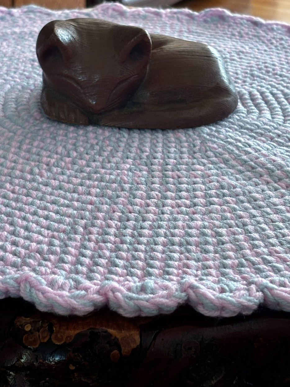 Close-up detail of the pink and gray acrylic crochet cat lounger, highlighting the handcrafted stitch texture and decorative scalloped border by Sleeping Whiskers Studio.