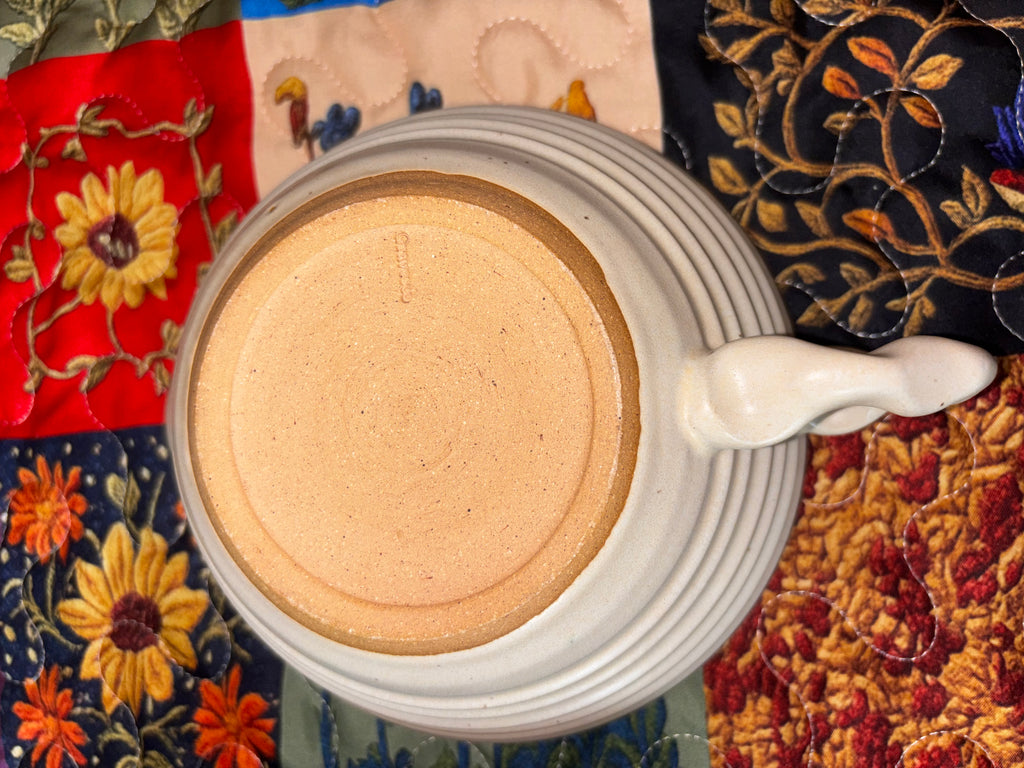 "Bottom of Gravesco handmade ceramic mixing bowl showing sculpted handle and potter's mark — signed artisan pottery"