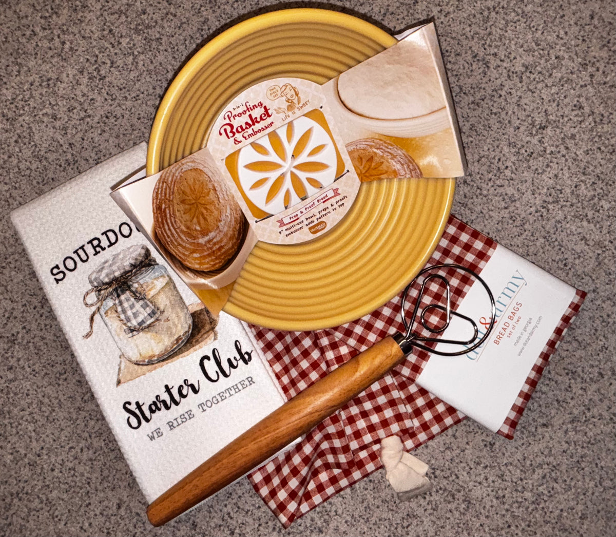 Danish dough whisk with a long wooden handle and heart-shaped stainless-steel coil on a light background.