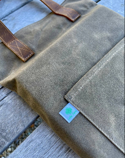 Celtic Farm waxed canvas garden kneeler showing hunter green canvas, Celtic Farm label, and leather handle detail