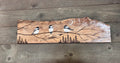On barn wood wall, straight on → "Chickadee Trio on Spalted Maple original wood burn art by Adirondack Art Co. displayed on a rustic barn wood surface, showing three hand-painted chickadees perched on a winter branch with pine trees and crescent moon"