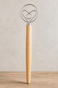 "13-inch Danish dough whisk with heart-shaped stainless-steel coil and natural wood handle, standing upright on a wooden surface against a neutral background"