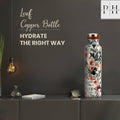 Floral-patterned water bottle on a dark surface with decorative elements and text.