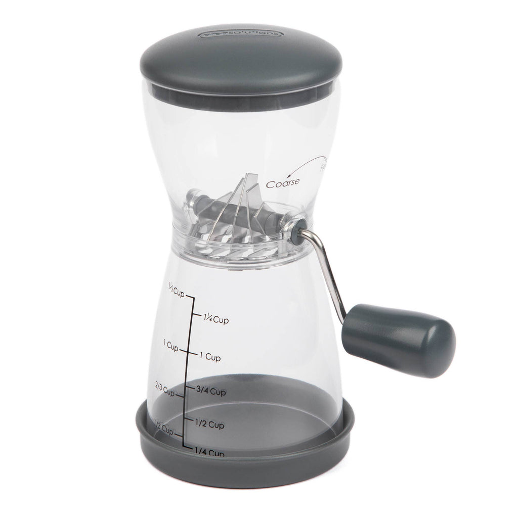 Progressive PrepSolutions 1⅓-cup nut chopper with clear BPA-free body, gray lid, non-skid base, crank handle, and measurement markings, displayed on a white background.