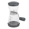 Progressive PrepSolutions 1⅓-cup nut chopper with clear BPA-free body, gray lid, non-skid base, crank handle, and measurement markings, displayed on a white background.