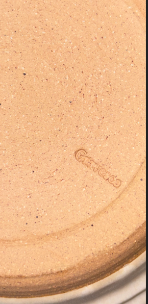 Close-up of Gravesco potter's mark on bottom of handmade cream ceramic mixing bowl"