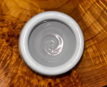 Top-down interior view on warm wood → "Overhead view of Farmhouse Pottery stoneware pickle pot showing the smooth white glazed interior with hand-thrown spiral detail, displayed on a warm wood surface"