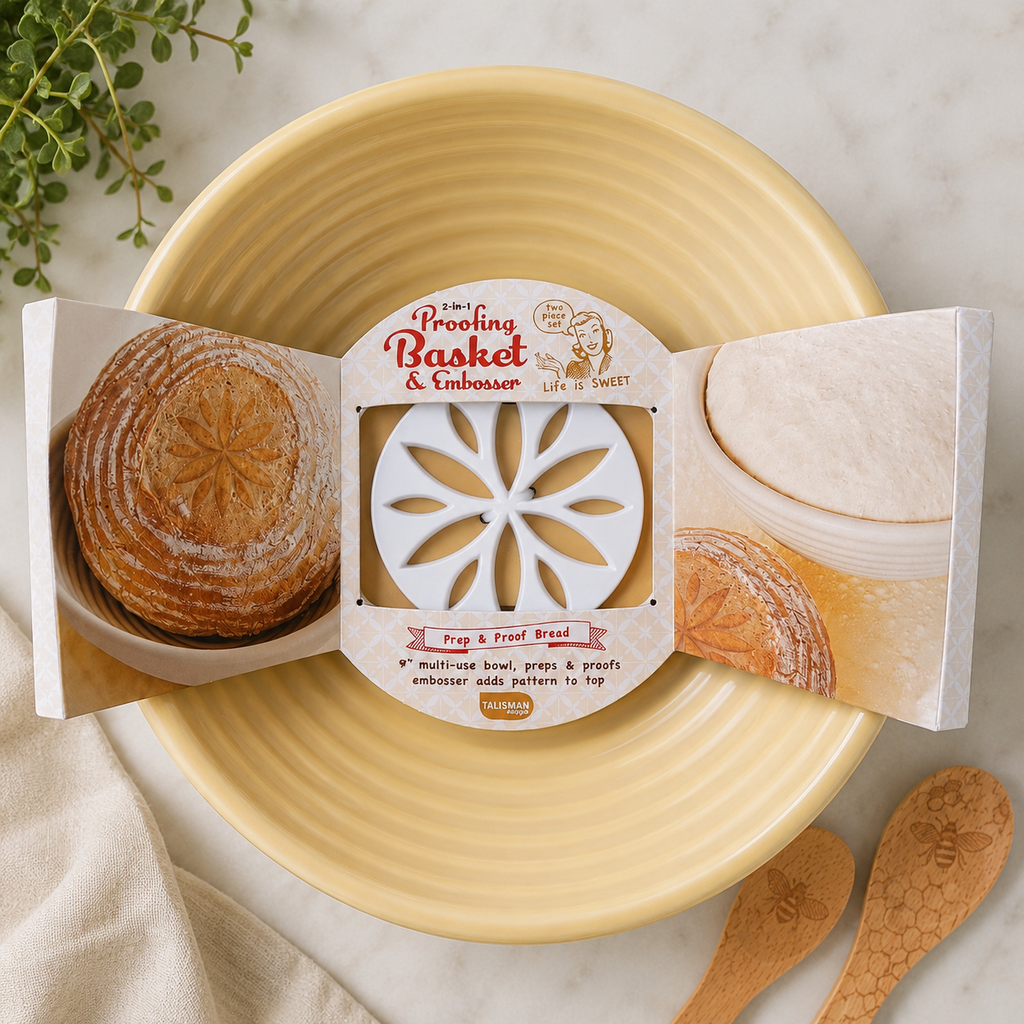 Talisman Designs 2-in-1 Proofing Basket and Embosser set in packaging, showing cream-colored ribbed bowl with white floral embosser disc, styled on marble with wooden spreaders and greenery"