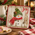 Park Designs Farmhouse Snowman holiday salad plate with 'Joy' sentiment, green knit hat, red scarf, and berry branches on a rustic wood background, styled with Christmas greenery and snowflake sugar cookies"