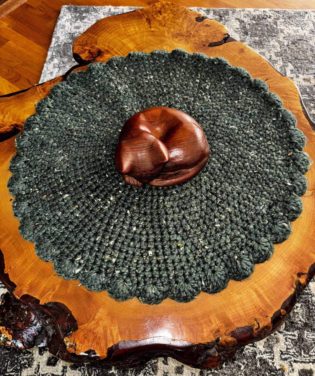 Top-down view of the deep green wool blend cat lounger, approximately 19¾ inches in diameter, with a decorative scalloped edge handcrafted by Sleeping Whiskers Studio.