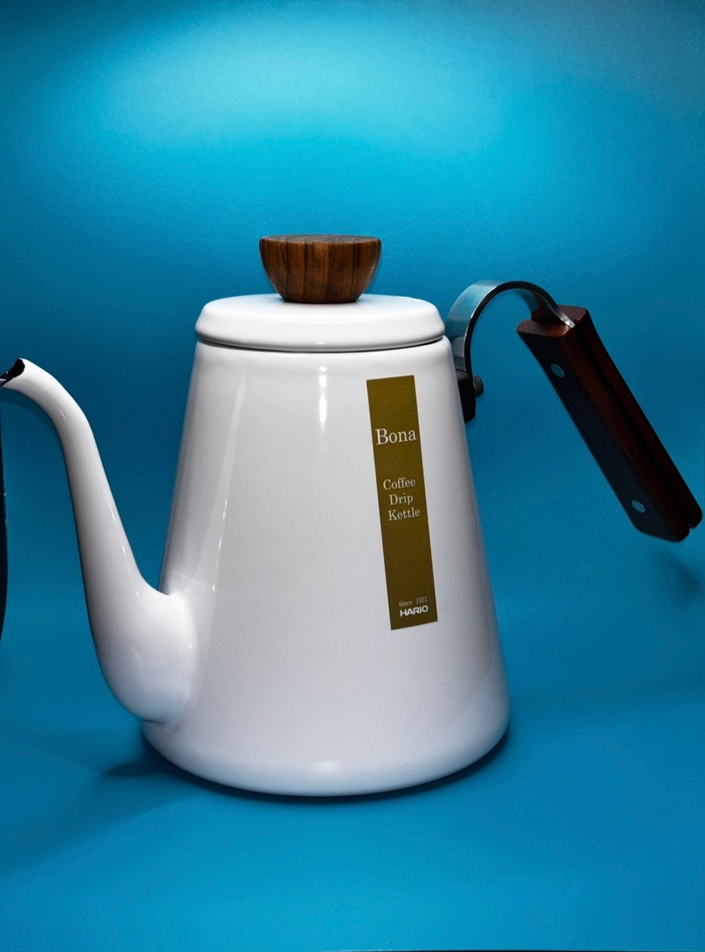 White enamel gooseneck pour over coffee kettle showing spout and walnut wood handle detail — Bona Coffee Drip Kettle on blue background"